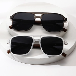 Polarized round-frame sunglasses set with wood grain temples on a stone pedestal