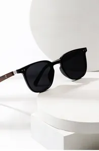 Detail of square polarized sunglasses with dark brown wood grain temples and metal accents