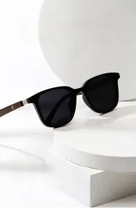 Detail einer polarisierten Sonnenbrille mit schwarzem Rahmen und dunklen Holzbügeln