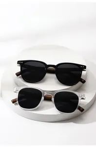 Detail of polarized round sunglasses with textured wood grain temples on white stands