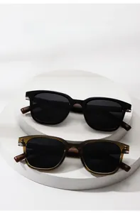 Detail der runden polarisierten Sonnenbrille mit Holzmaserung auf weißem Podestständer