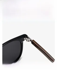 Detail of polarized sunglasses showing wood grain temple with silver metal hinge