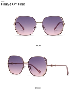 Detail view of gold hexagonal frame sunglasses with pink gradient lenses and ring trim