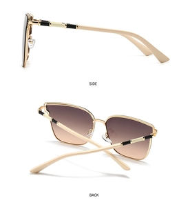 Detail view of gold metal frame sunglasses with gradient lenses and color-block temples