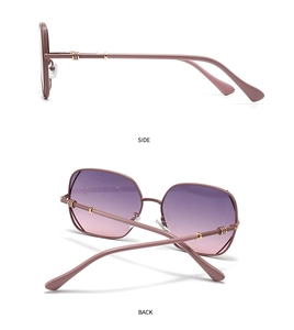 Detail view of pink gradient sunglasses with decorative gold metal rings on the temples