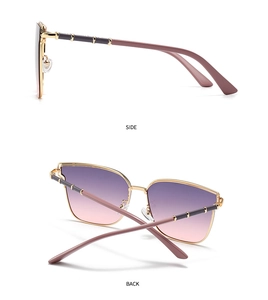 Detail view of gold metal sunglasses frames with purple gradient lenses and bamboo-style legs