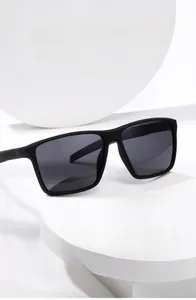 Detailed view of square black matte sunglasses on a white geometric display stand