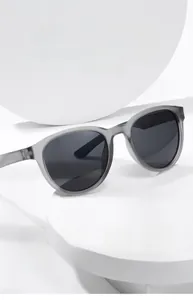 Detail view of round grey matte sunglasses with polarized lenses on a white platform