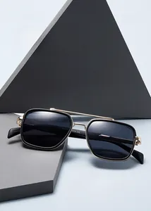 Detail of trendy narrow rectangle sunglasses with black frame and gold metal double bridge
