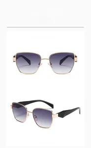 Close-up of golden metal frame sunglasses with gray gradient lenses and faceted black temples