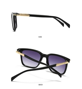 Detail view of black full-rim sunglasses with textured gold metal temples and gradient lenses