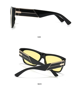 Detail view showing black square frame with gold metal accents and yellow lenses