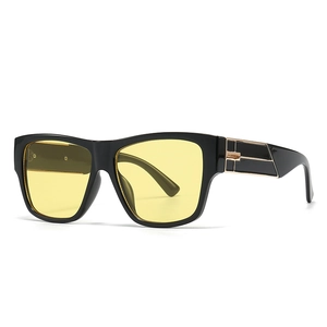 Modern square sunglasses for women with black frames, yellow lenses, and gold metal accents