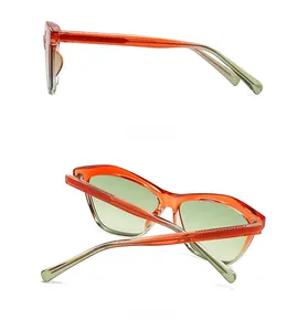 Detail view of orange translucent cat-eye sunglasses with green lenses and side frame structure
