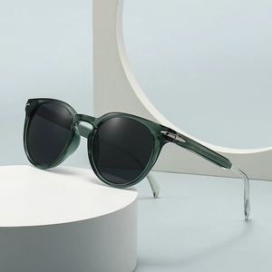 Fashionable round sunglasses with transparent dark green frames and silver arrow accents