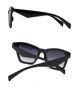 Detail view showing the side and back of oversized black cat-eye sunglasses with gradient lenses