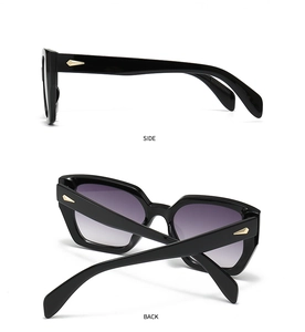 Detail view of black square sunglasses with golden arrow metal decor and purple gradient lenses