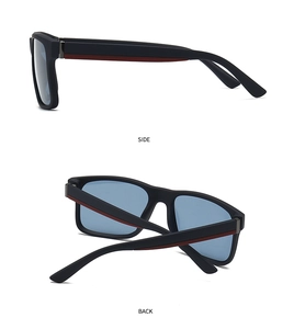 Detail view of square matte black sunglasses with red side stripes and blue lenses