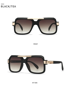 Close-up of black square aviator sunglasses with gold metal accents and tea gradient lenses