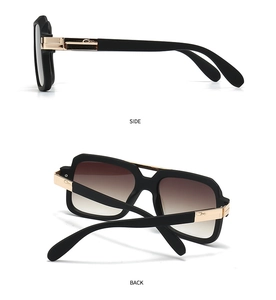 Detail of black square pilot sunglasses with gold metal hinges and side logo engraving