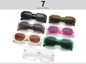 Flat lay of seven stylish oval sunglasses in multiple colors with metallic rivet accents
