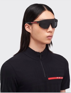 Side view of oversized wrap-around sports sunglasses with iconic red stripe detail