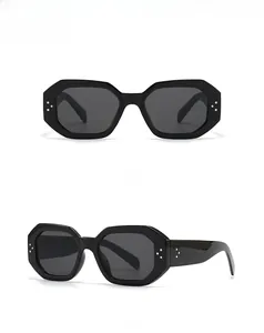 Close-up of black octagonal sunglasses featuring silver triple-dot rivets and dark lenses