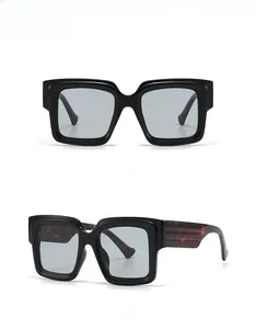 Detail of square black glasses with thick frames and subtle red marble temple texture