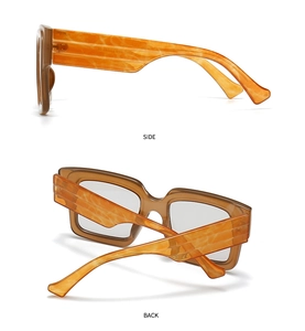 Detail view showing the amber orange temples and translucent tea frames of these glasses