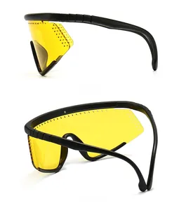 Detail view of matte black sport goggles featuring yellow oversized lenses and side vents