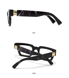Detail view of stylish black eyeglasses frame with marble pattern temples and H gold hinge