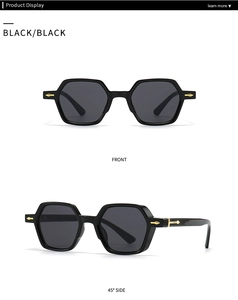 Close-up of black hexagonal sunglasses with golden arrow accents on the side frames