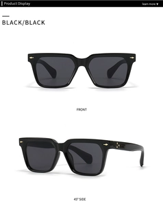 Close-up of square butterfly sunglasses with black frames and iconic gold arrow rivets