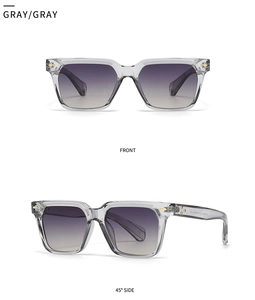 Detail view of square sun glasses with transparent grey frames and purple gradient lenses
