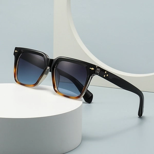 Square butterfly sunglasses in black and amber with blue gradient lenses on a white base