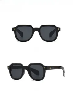 Vue macro des lunettes de soleil noires à monture épaisse avec accents métalliques dorés