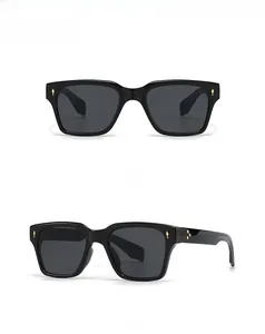 Détail de lunettes de soleil carrées papillon avec charnières dorées et monture noire