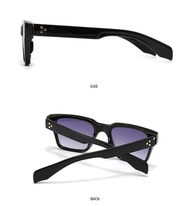 Détail de lunettes noires avec verres dégradés violets et rivets en étoile dorée