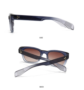 Detail view of transparent grey-blue sunglasses with golden rivets and gradient lenses