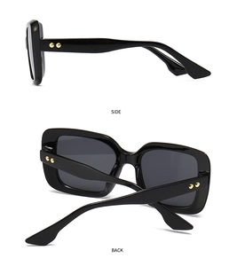 Detailansicht der schwarzen quadratischen Sonnenbrille mit goldenen Nieten an der Seite