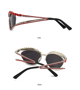 Détail de lunettes de soleil œil de chat avec strass rouges et verres noirs