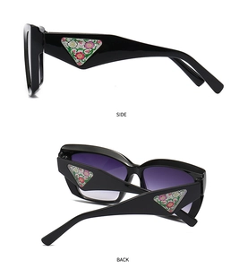 Detail view of cat-eye sunglasses with side floral triangle inlay and purple gradient lens