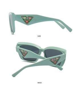 Detail view of mint green sunglasses with floral triangle inlay on the wide side temple