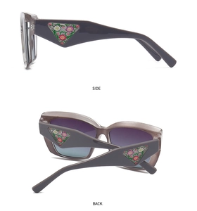 Detail view of mauve cat-eye sunglasses with triangular floral side metal decoration