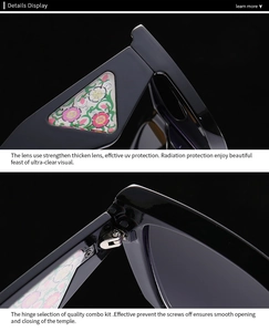 Close-up of black sunglasses with floral triangle detail and sturdy metal hinges