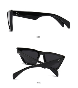 Detail view showing the side and back of black cat-eye sunglasses with silver dot accents