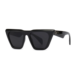Modern cat-eye sunglasses with thick black frames and metal rivets in a front-side view