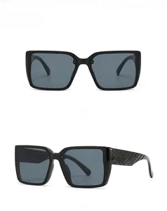 Detail view of black oversized square sunglasses with V-shaped geometric temple relief