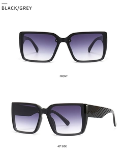 Detail view of large square black sunglasses with gradient purple lenses and chevron texture