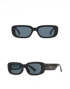 Détail de lunettes de soleil rectangulaires noires avec motifs papillons colorés sur les branches